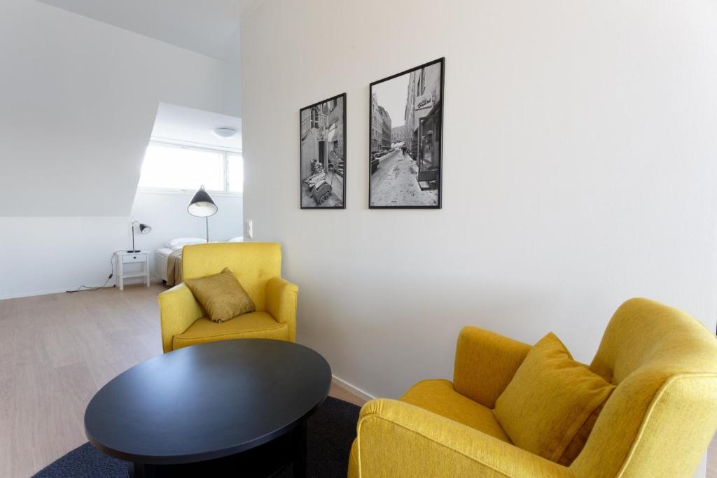 a living room with two chairs and a table at Forenom Serviced Apartments Helsinki Kruununhaka in Helsinki