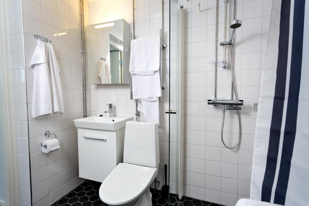 a bathroom with a toilet and a sink and a shower at Forenom Serviced Apartments Helsinki Kruununhaka in Helsinki