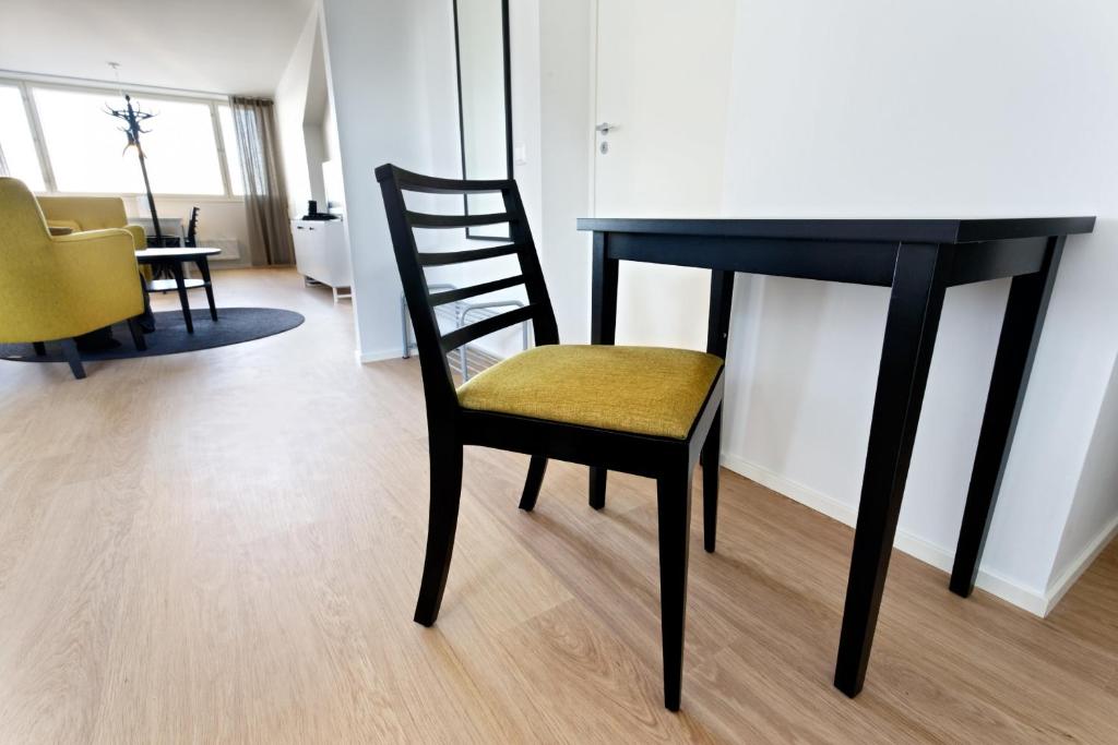 a dining room table with a chair and a desk at Forenom Serviced Apartments Helsinki Kruununhaka in Helsinki
