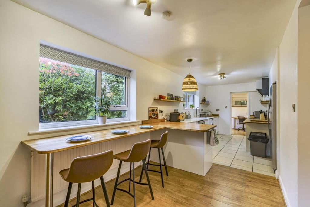 a kitchen with a wooden counter and stools at The Laurels - Wifi, Parking, 4 Bedrooms, Gatwick in Crawley