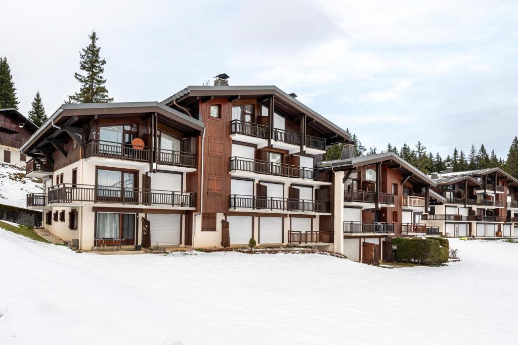un grand immeuble dans la neige dans l'établissement Bel appartement au pied des pistes, à Notre-Dame-de-Bellecombe