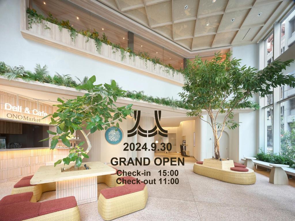 東京にある三井ガーデンホテル銀座築地の建物内の木やベンチのあるロビー