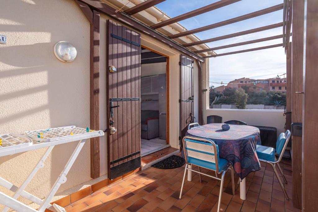 une pièce avec une table et des chaises sur un balcon dans l'établissement Les Sablons, à Leucate