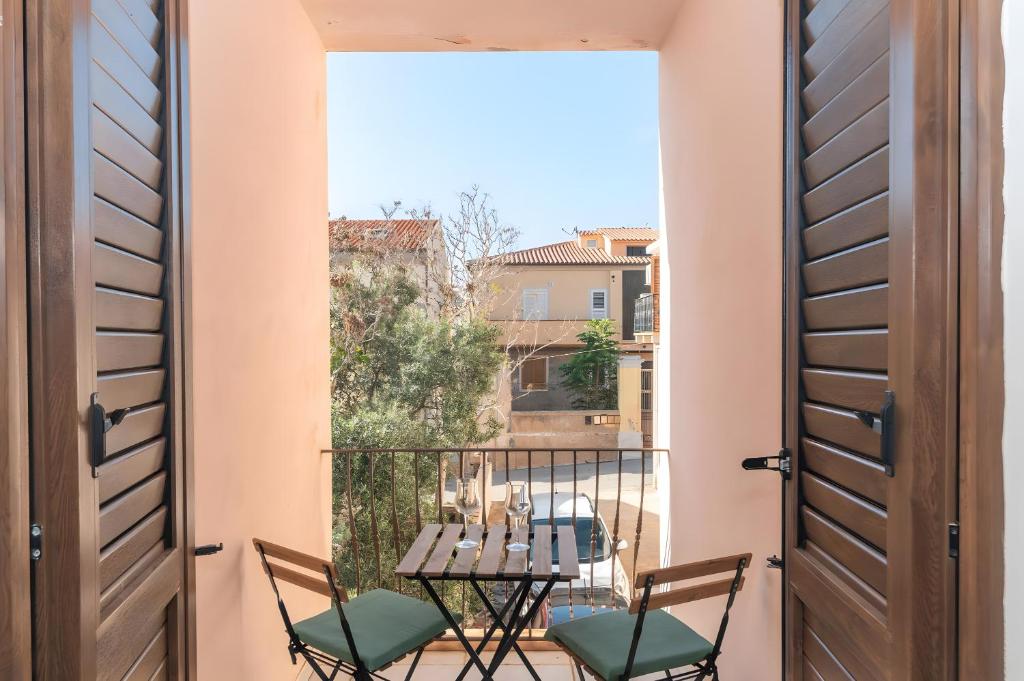Una habitación con balcón con mesa y sillas. en Residenza le Giare, en La Maddalena