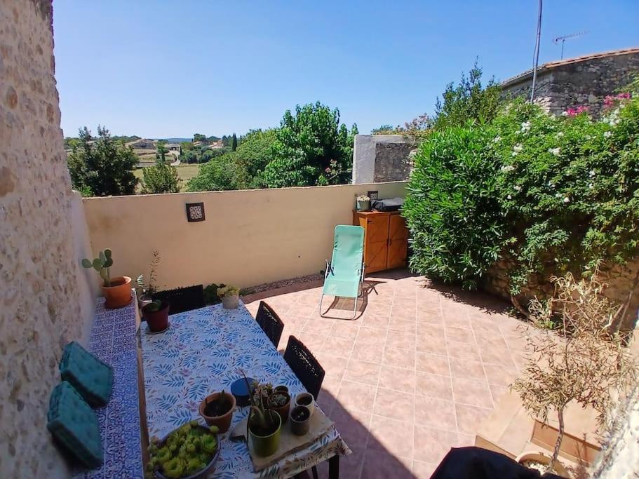 La RouvièreにあるMaison de village cosy, grande terrasse dominanteのパティオ(果物を用意したテーブル付)