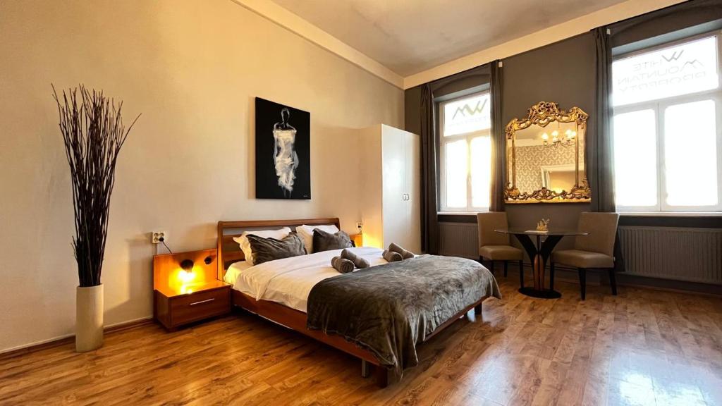 Un dormitorio con una cama, una mesa y un espejo. en The Stag Ultracentral OldTown Apartment, en Brasov