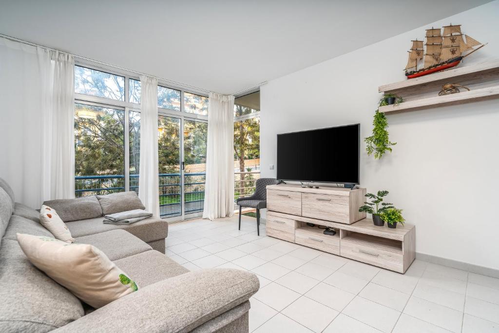 a living room with a couch and a flat screen tv at Sea Breeze in Portimão