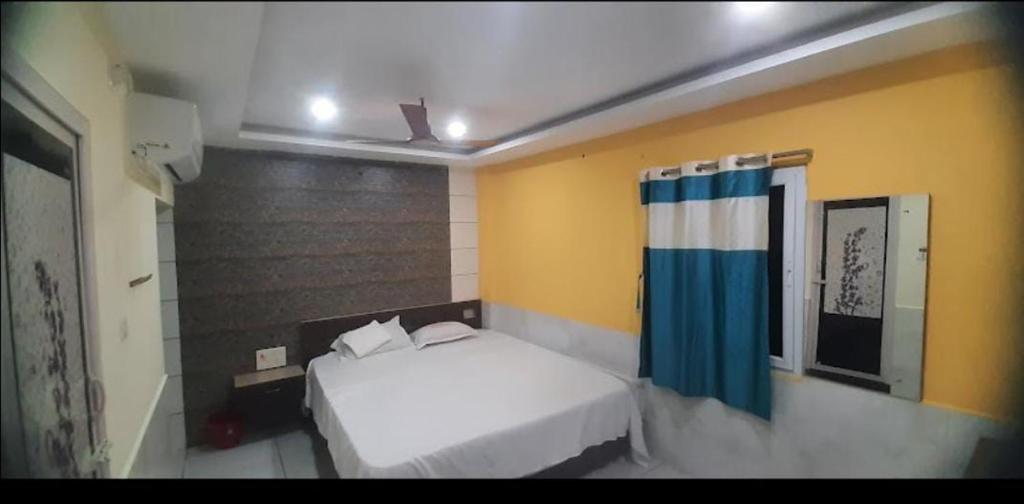 1 dormitorio con cama blanca y paredes amarillas en Panneer residency, en Tiruvannāmalai