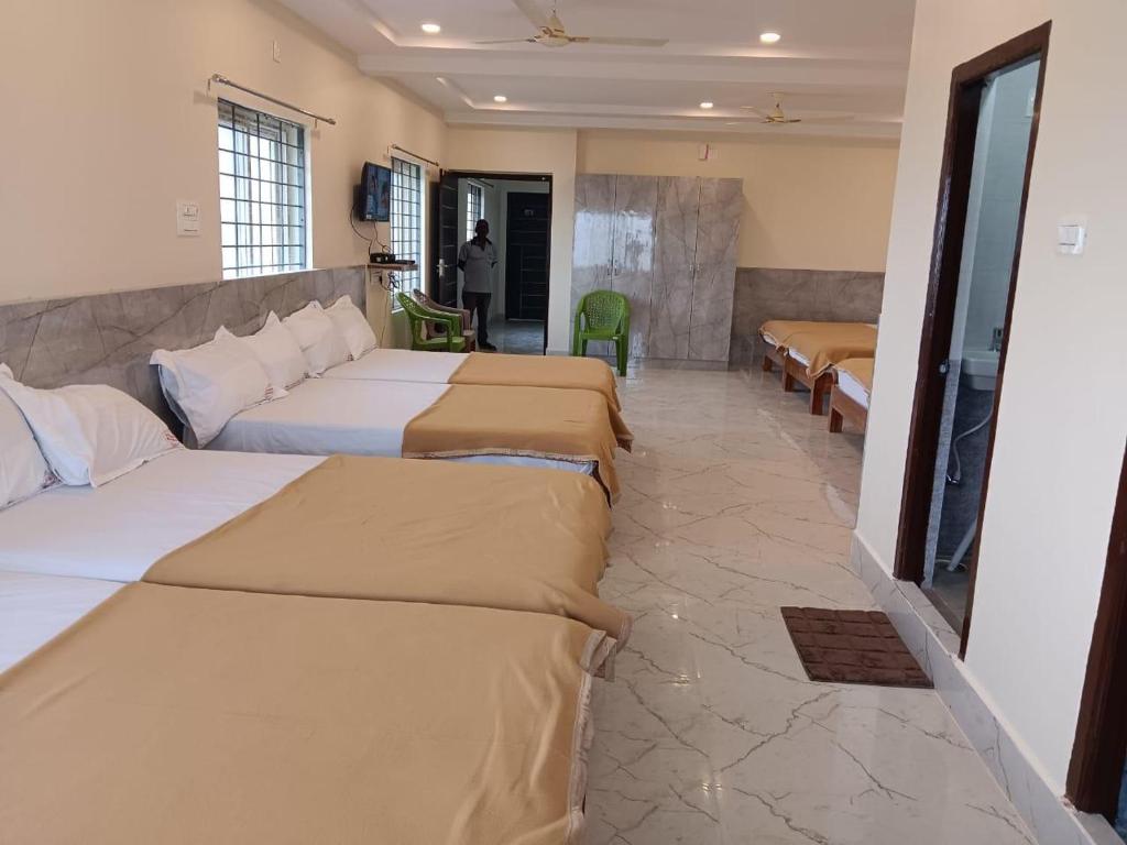 Postel nebo postele na pokoji v ubytování Sri Ganesh Residency