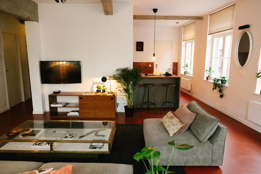 un soggiorno con un divano e un tavolo di Aplace Antwerp - marvellous flats & hotel rooms - Leeuwenstraat 20 ad Anversa