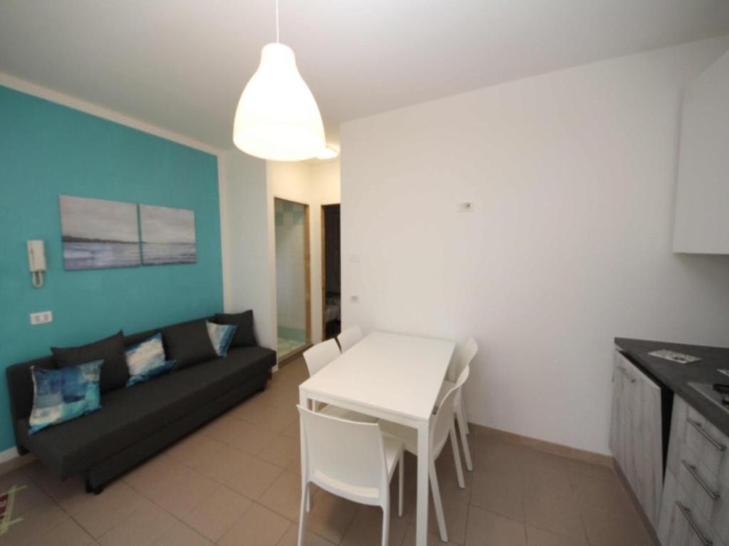 a living room with a black couch and a white table at Renovated flat located in Rosolina near the sea in Rosolina Mare