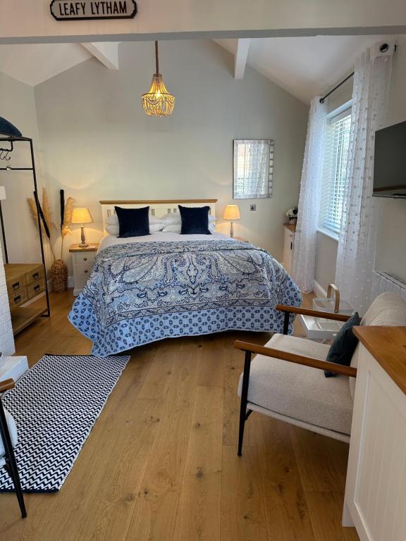 a bedroom with a bed with a blue bedspread at The Old Wash House in Lytham St Annes