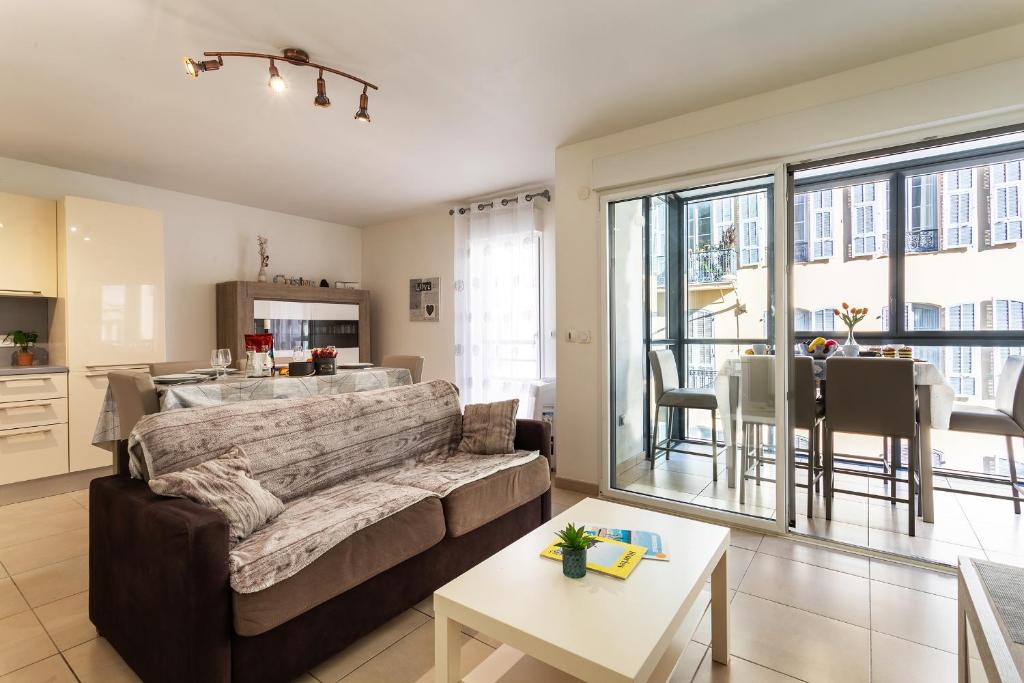 un salon avec un canapé et une table dans l'établissement JARDINS MASSENA AP4088 Nice, by Riviera Holiday Homes, à Nice