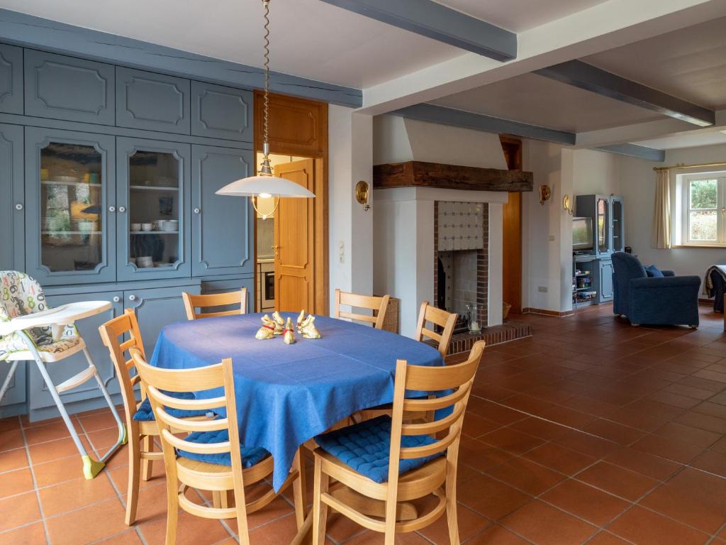 a dining room with a blue table and chairs at Kaapdüne in Spiekeroog