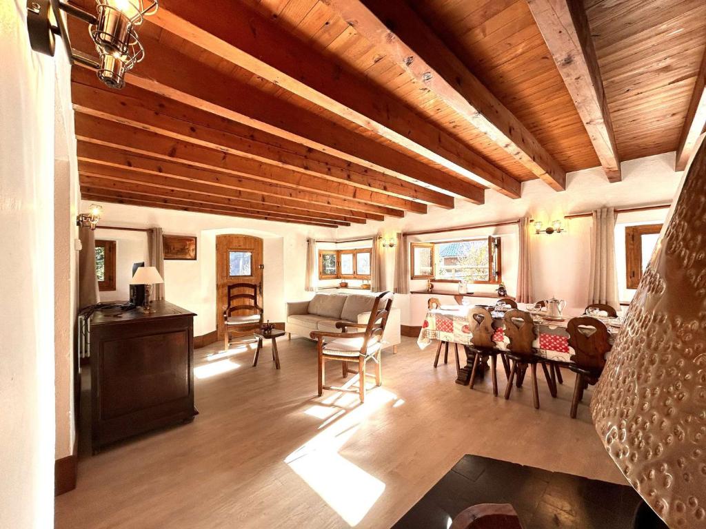 a living room with a wooden ceiling and a table at Chalet en Pierre 4 P. pour 6 Pers. à Méribel, Navette Gratuite et Grande Terrasse - FR-1-180-583 in Les Allues