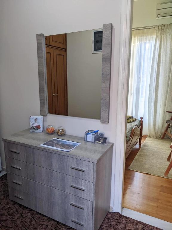 łazienka z umywalką i dużym lustrem w obiekcie Small House for Holidays w mieście Leonidion
