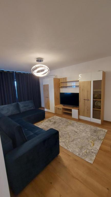 Una sala de estar con un sofá azul y un televisor. en Casa Dinca, en Craiova