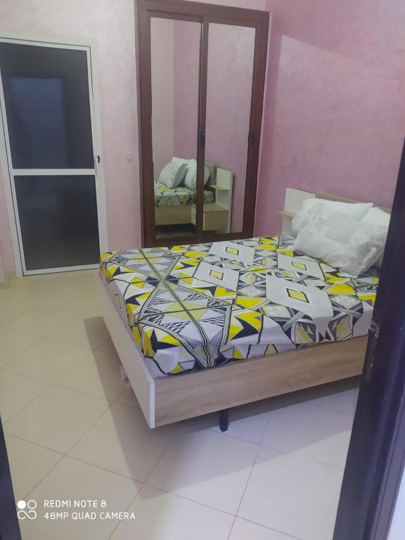 a bedroom with a bed and a mirror at Volubilis RDZ El Fateh in Meknès