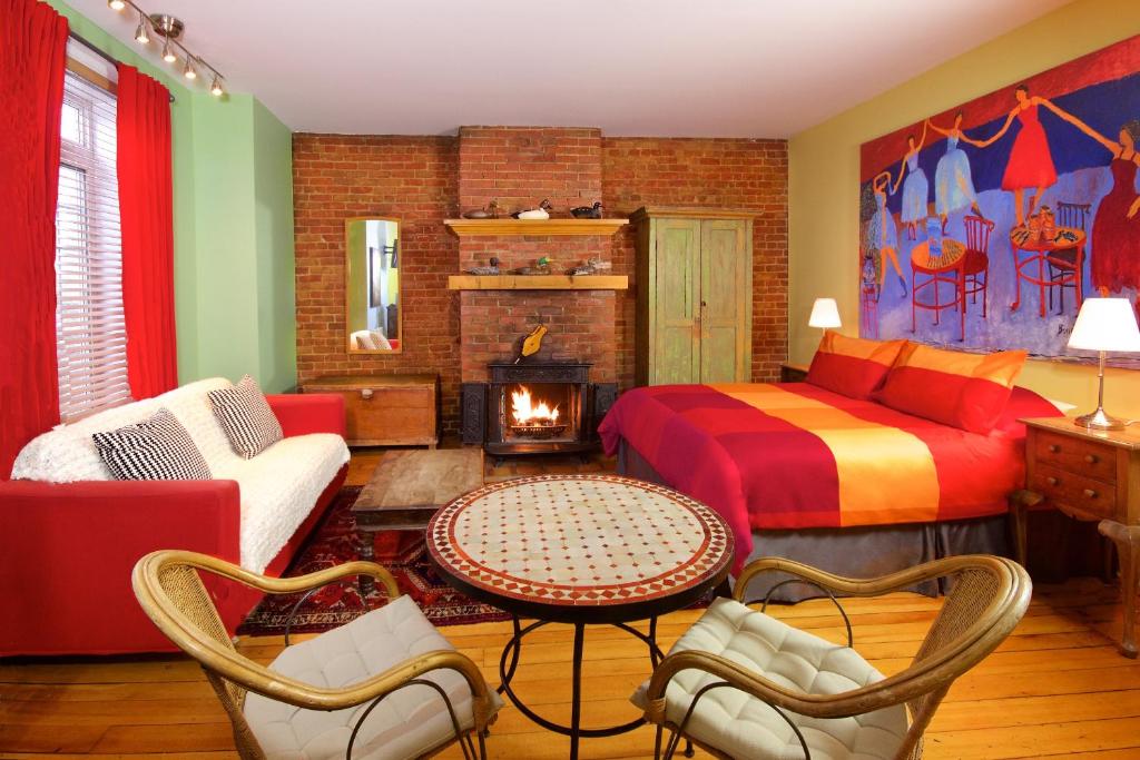 ein Wohnzimmer mit einem Bett und einem Kamin in der Unterkunft Auberge Les Bons Matins in Montreal