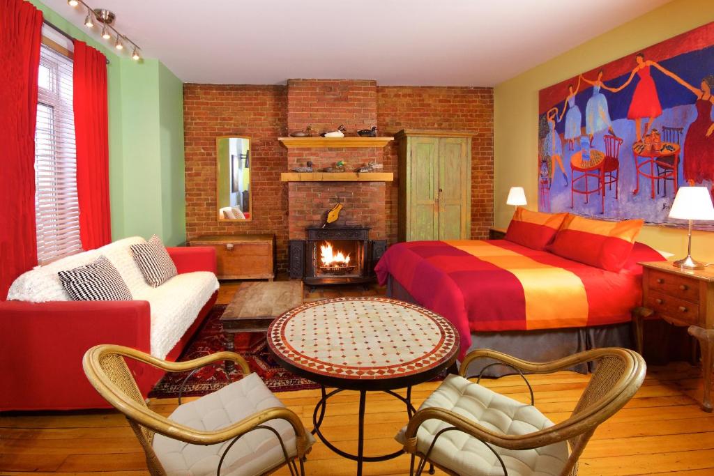 sala de estar con cama y chimenea en Auberge Les Bons Matins, en Montreal