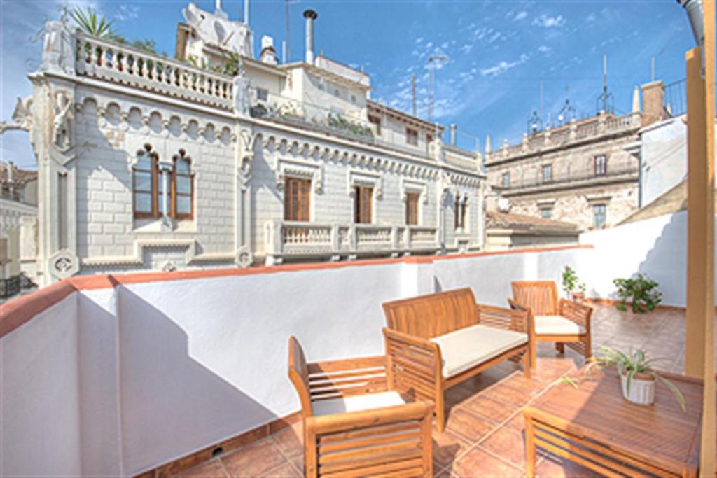 a balcony with two wooden chairs and a building at Beds & Breaks Pergolesi in Valencia