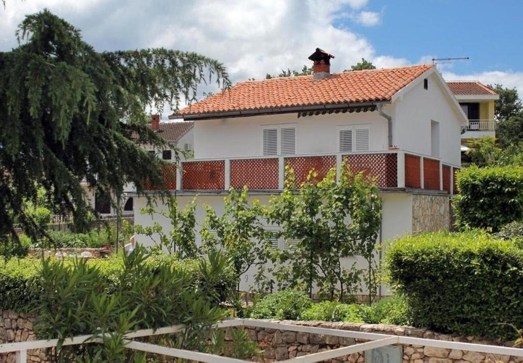 ein weißes Haus mit einem roten Dach in der Unterkunft Apartment Ljerka in Malinska