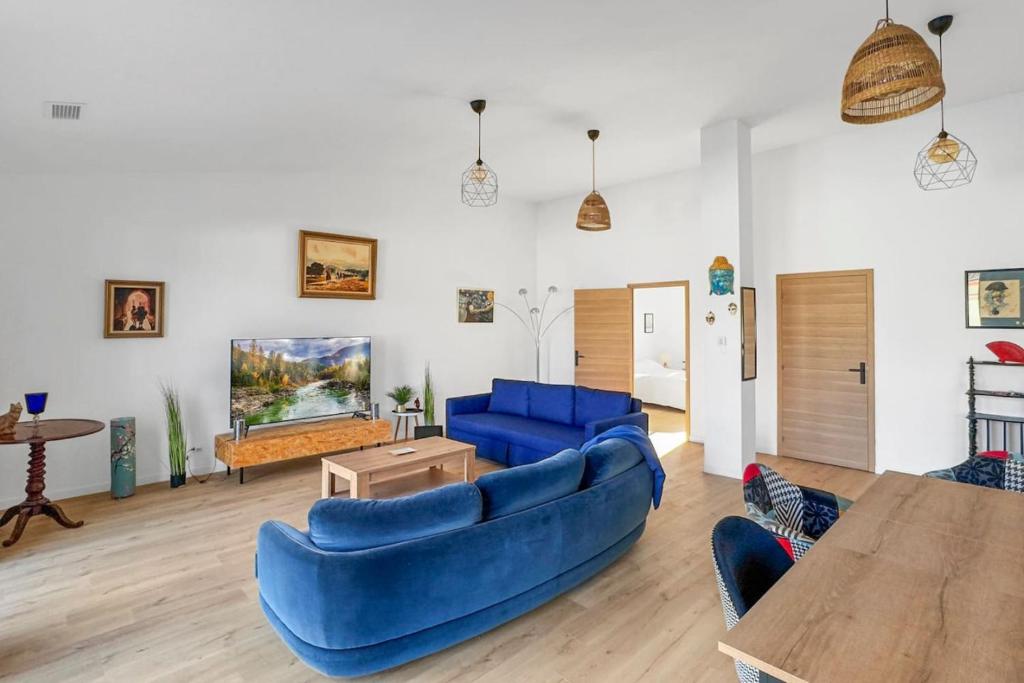 ein Wohnzimmer mit blauen Sofas und einem Fernseher in der Unterkunft Grande Villa de 400m2 21 Personnes en centre ville de Toulouse in Toulouse
