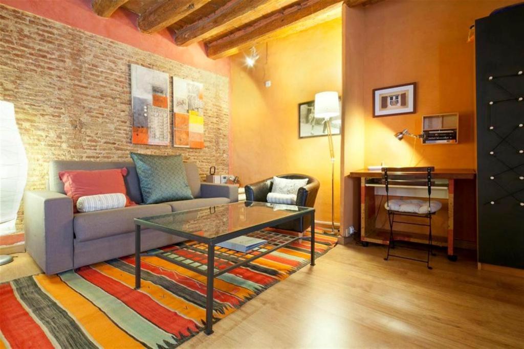 - un salon avec un canapé et une table en verre dans l'établissement Friendly Rentals Manuela, à Barcelone