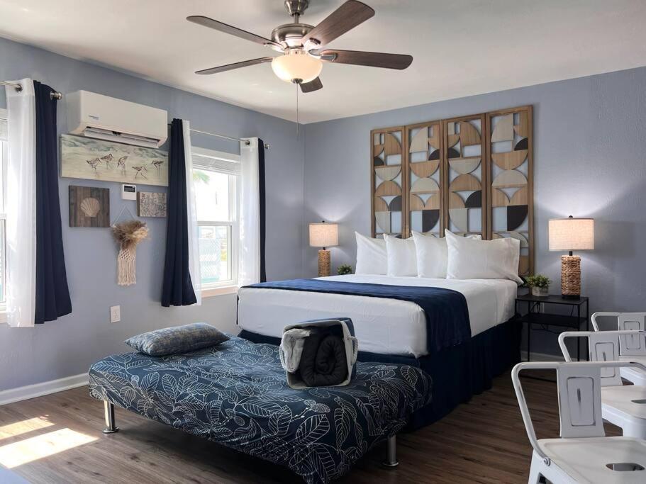 a bedroom with a bed and a ottoman and a ceiling fan at The Mark at Surfside #5 in Surfside Beach
