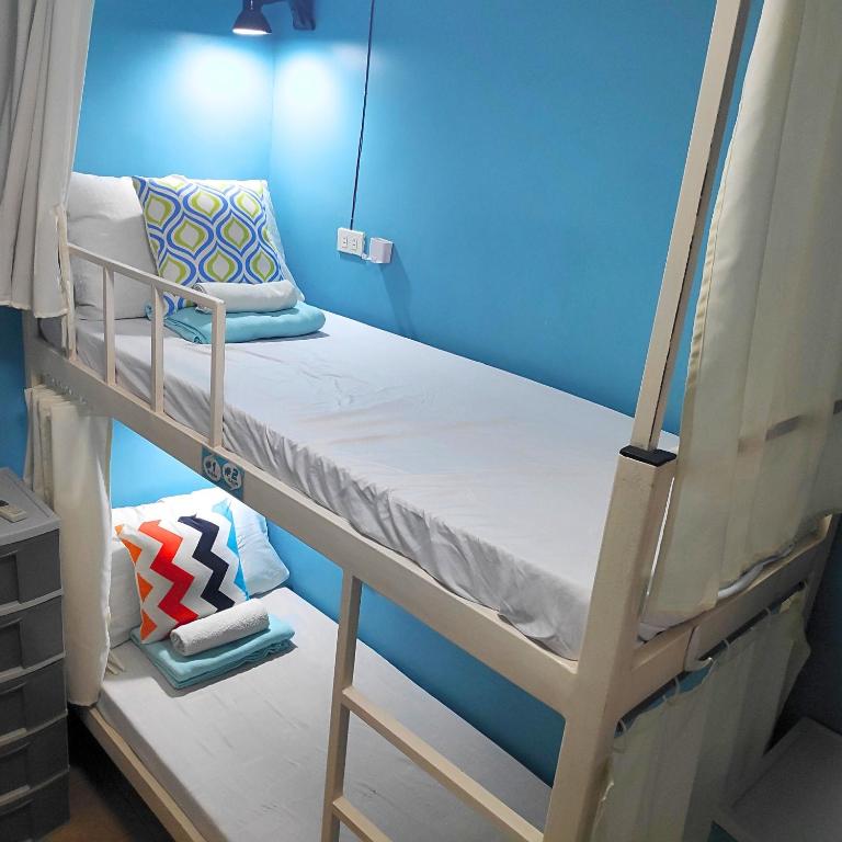 a bunk bed in a room with a blue wall at Crossroads Hostel Manila in Manila