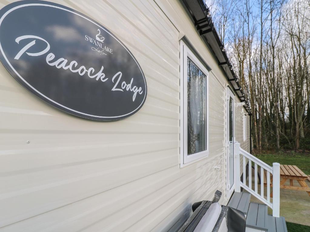 um sinal ao lado de uma casa em Peacock Lodge em Coalville