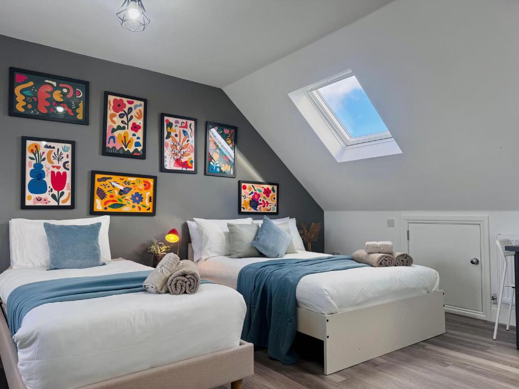Hotel Bright Studio Loft 30min to Central London, a bedroom with two beds and pictures on the wall at Bright Studio Loft 30min to Central London in London