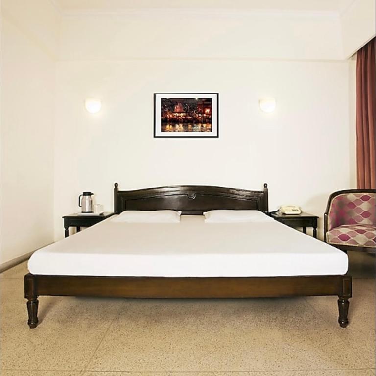 兰奇Bimala Hotel的带床和椅子的卧室