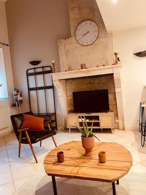 d'un salon avec une cheminée et une horloge murale. dans l'établissement La Cigogne, à Châteauvillain