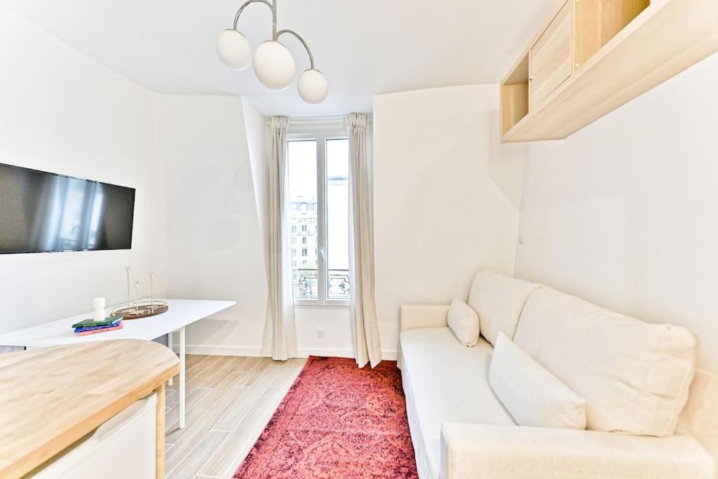 un salon avec un canapé blanc et une table dans l'établissement Studio à 10 minutes de la Basilique du Sacré-Cœur, à Paris