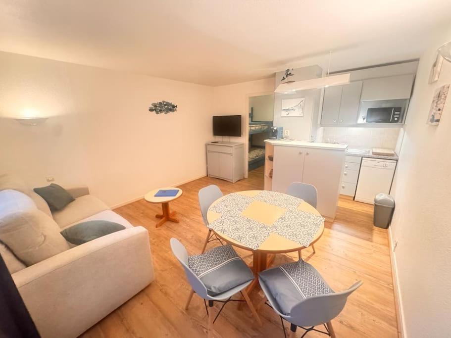 un salon avec un canapé et une table avec des chaises dans l'établissement Evasion marine Studio calme à 2 pas de la plage, à La Baule