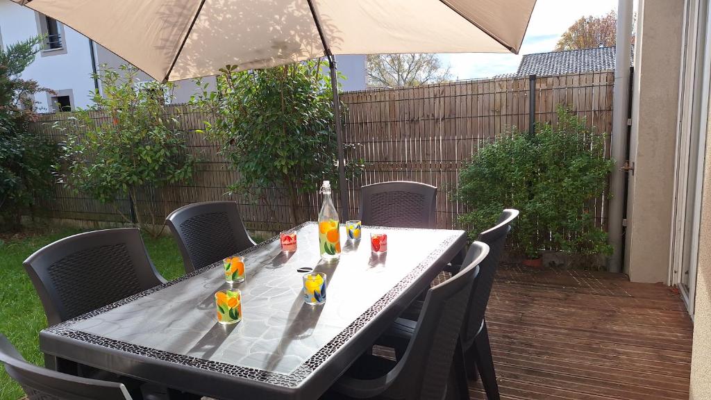 - une table avec une bouteille et des boissons dans l'établissement Agréable duplex avec jardin et terrasse, à La Teste-de-Buch