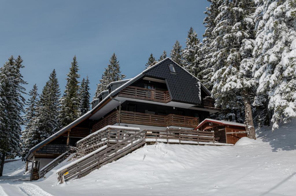 a log cabin in the snow with trees at Old House - Krvavec ski resort in Cerklje na Gorenjskem