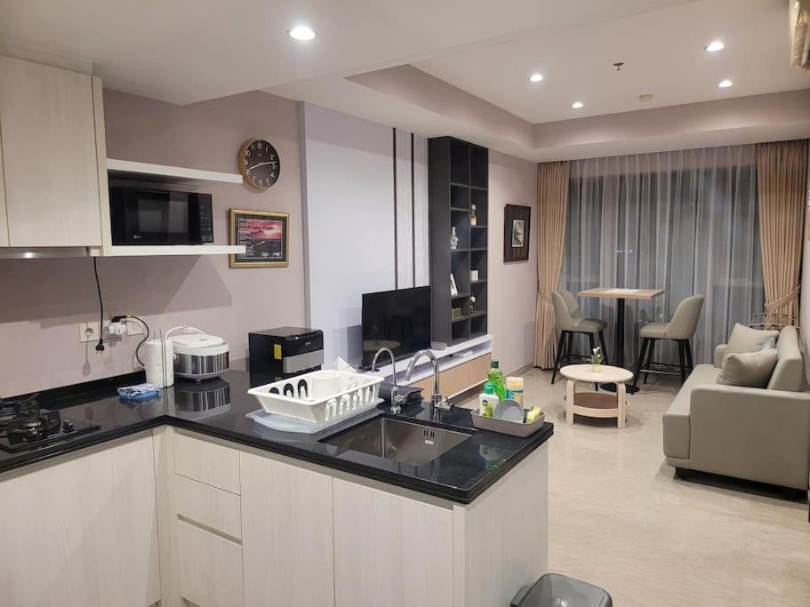 当格浪Homey 1 BR Apt at Branz BSD的厨房和带沙发的客厅