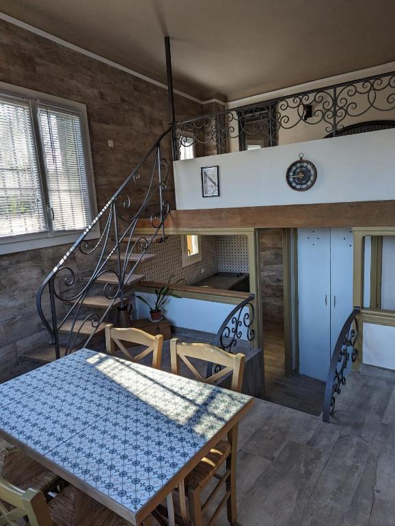 a dining room with a table and a staircase at Petit LOFT Jardin Terrasse Climatisation WI FI Parking public gratuit in Elne