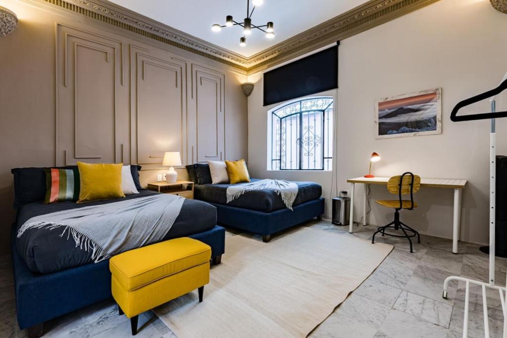 een slaapkamer met een bed, een bank en een bureau bij Roma Elite Residence Spacious and Elegant in Mexico-Stad