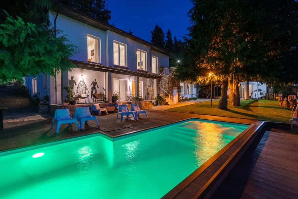 a swimming pool in front of a house at night at Casa Avó Chiquinha in Montalegre