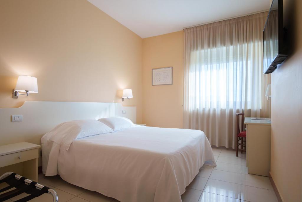 a hotel room with a white bed and a window at Barion Hotel & Congressi in Bari