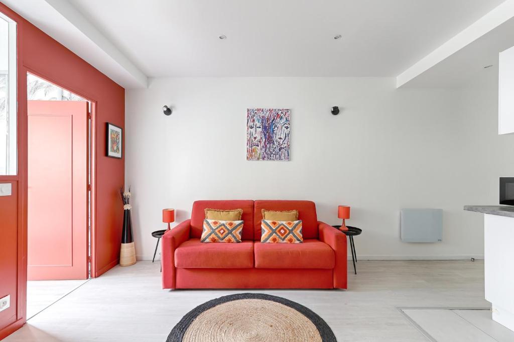 - un canapé rouge dans le salon aux murs rouges dans l'établissement Saint Fargeau Gambetta III Lovely Apartment 4P-1BR, à Paris