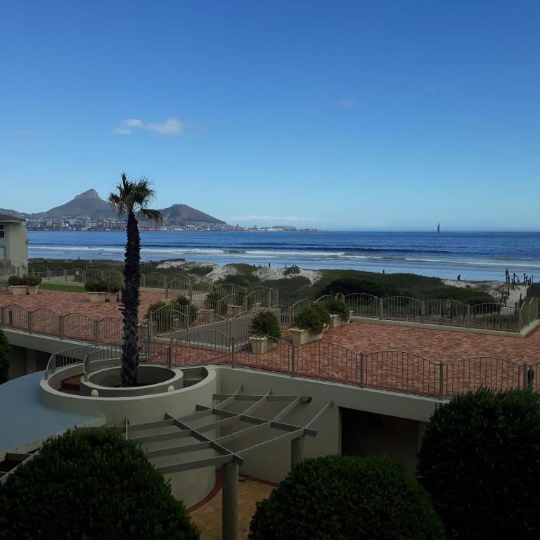 a view of the ocean from a resort with a palm tree at 215 Sea View in Cape Town