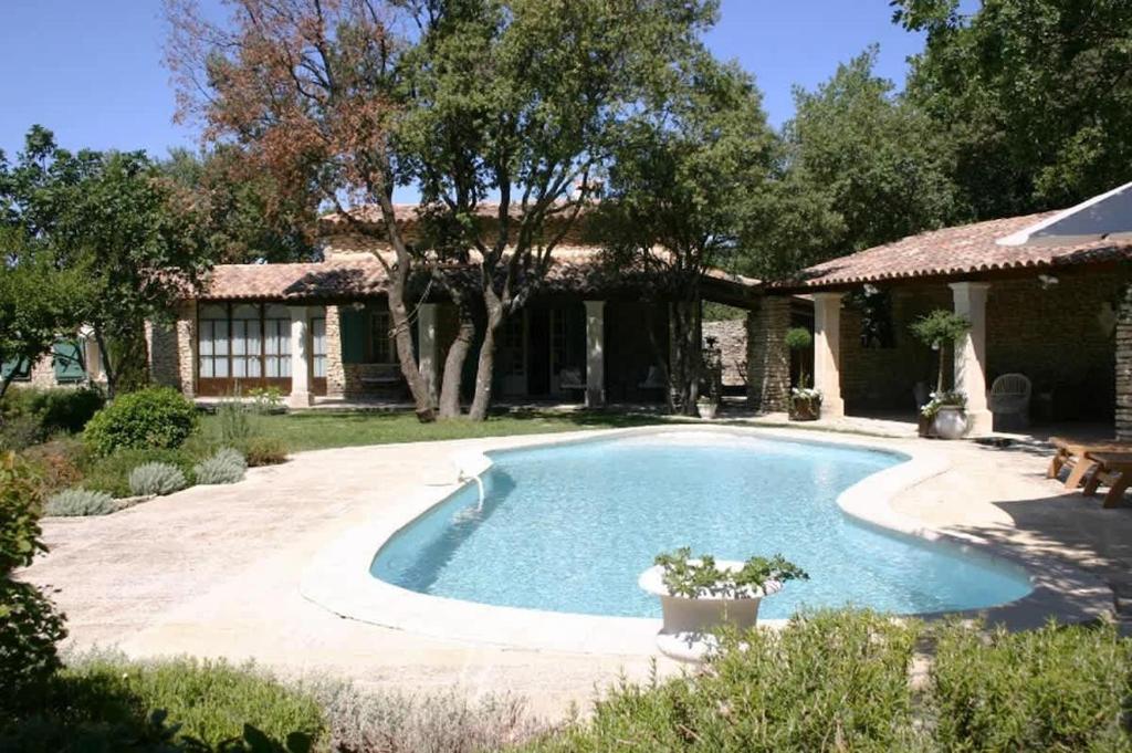 une piscine devant une maison dans l'établissement Villa La Raffinée, au coeur des garrigues du Luberon, à Gordes