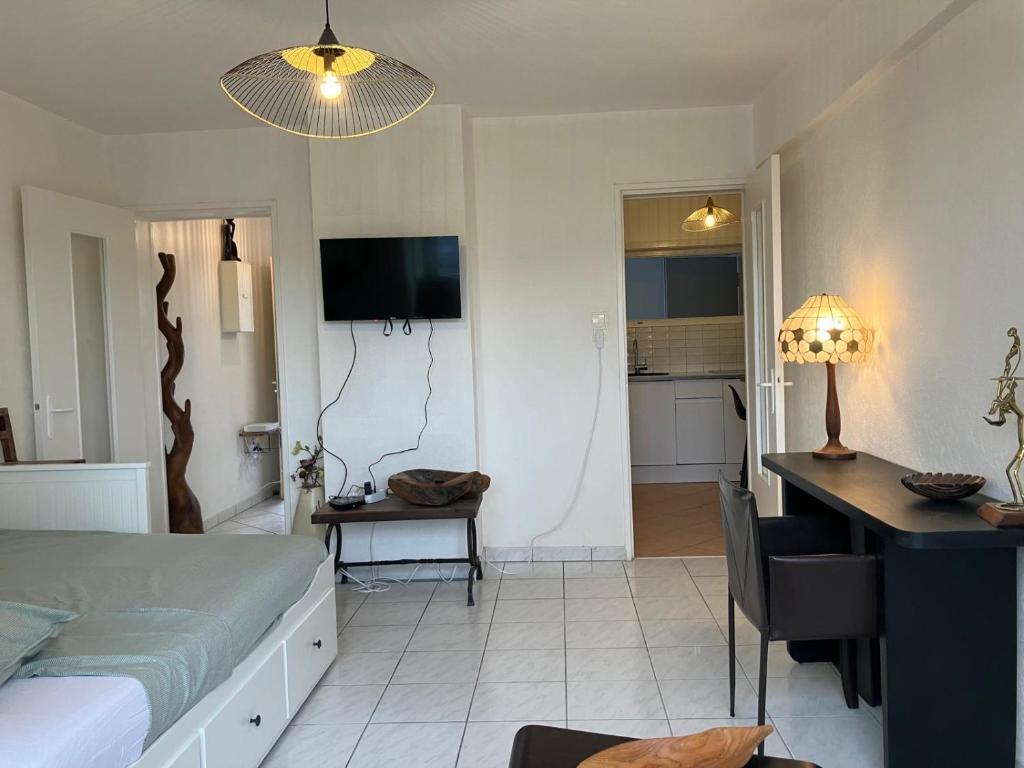 a bedroom with a bed and a table and a desk at Studio Cosy Illkirch in Strasbourg