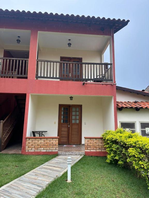 a red and white house with a balcony at Villa Zen Pirenópolis Conforto e Bem-Estar in Pirenópolis