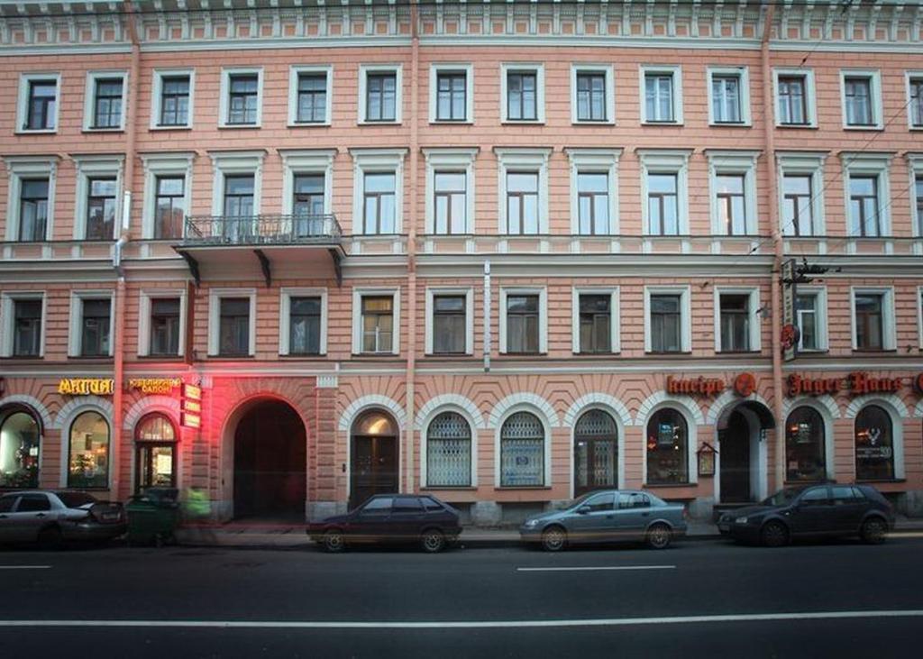 un gran edificio de ladrillo con coches estacionados frente a él en Capital, en San Petersburgo