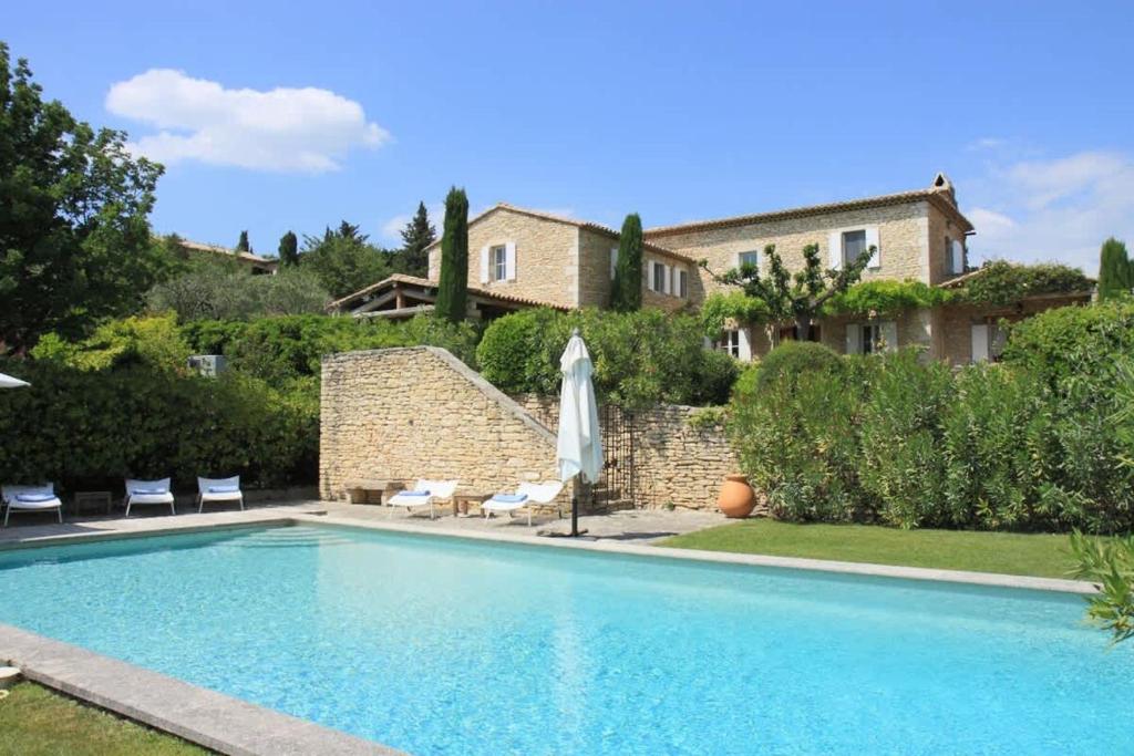 une piscine devant une maison dans l'établissement Villa l'Écrin, piscine et 3 terrasses, à Gordes
